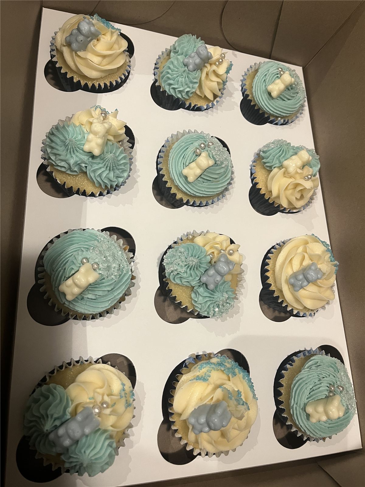 Tray of blue and cream decorated cupcakes