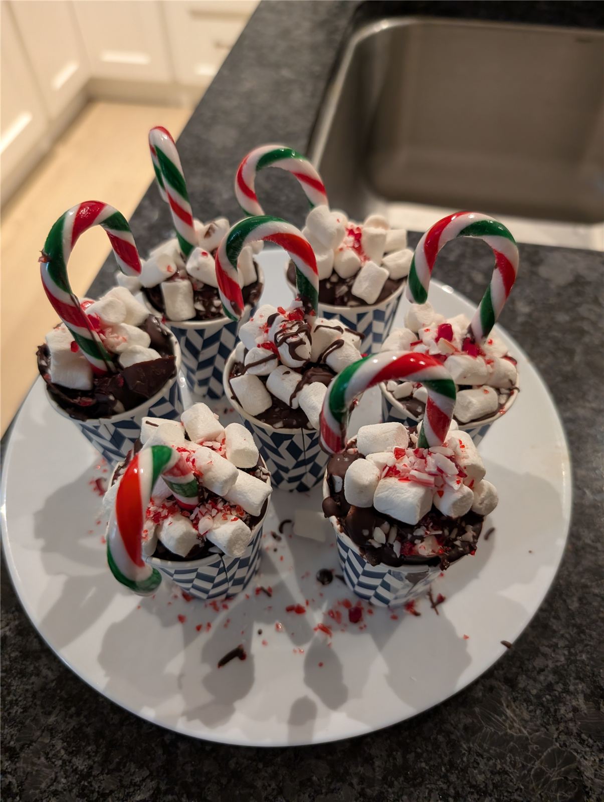 Hot cocoa bombs topped with marshmallows and candy canes