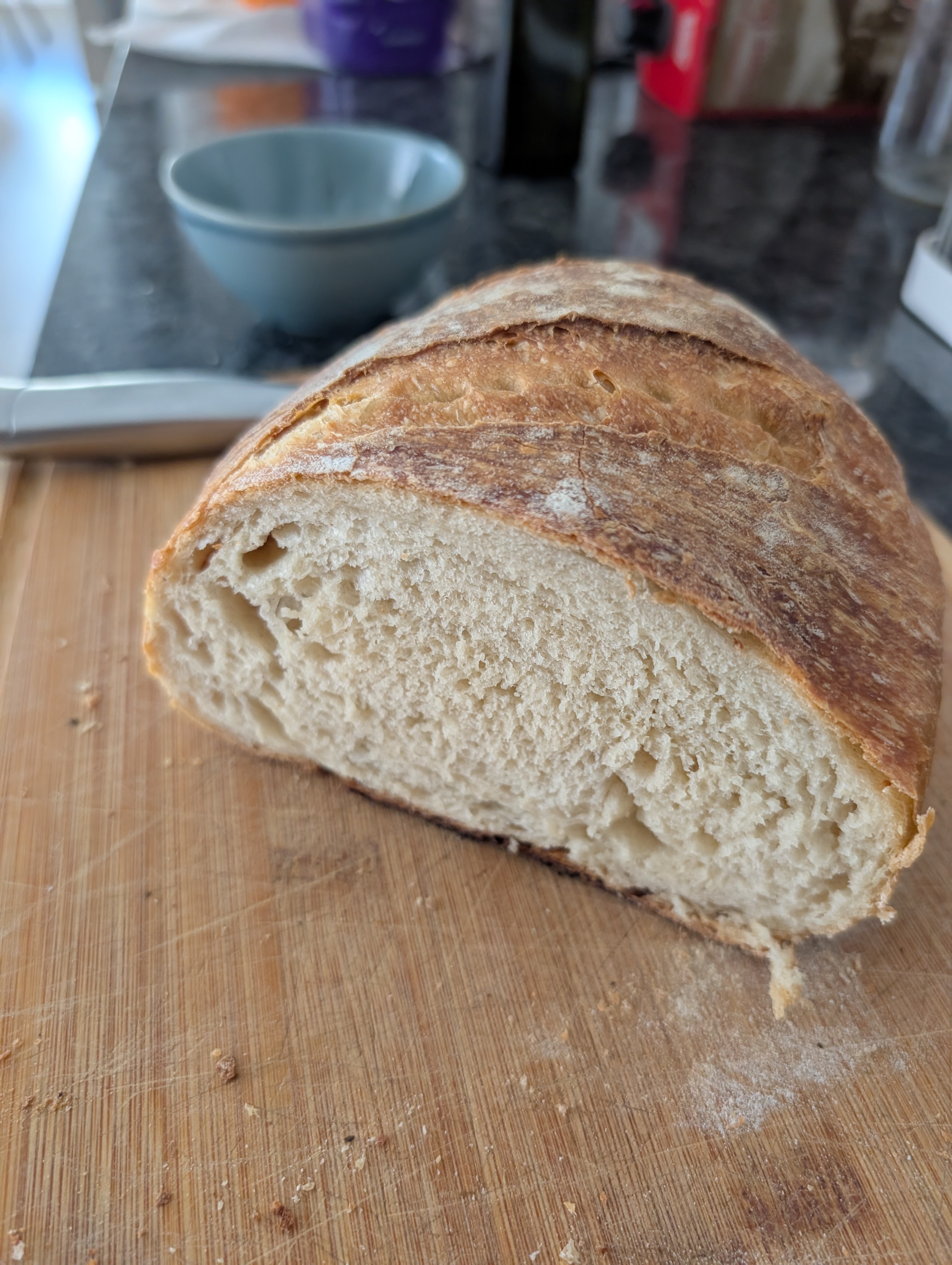 Sourdough loaf sliced open showing the airy crumb on a wooden board