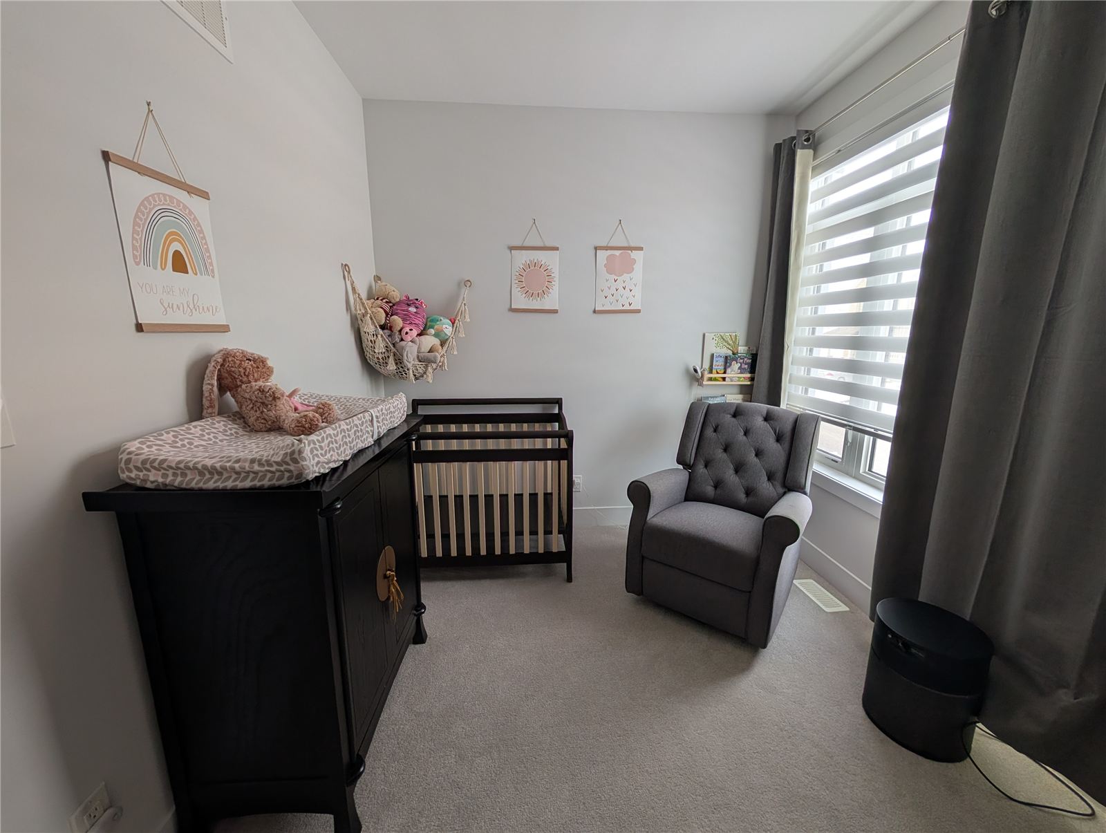 Nursery with the refinished dark mini crib beside a matching dresser and changing table