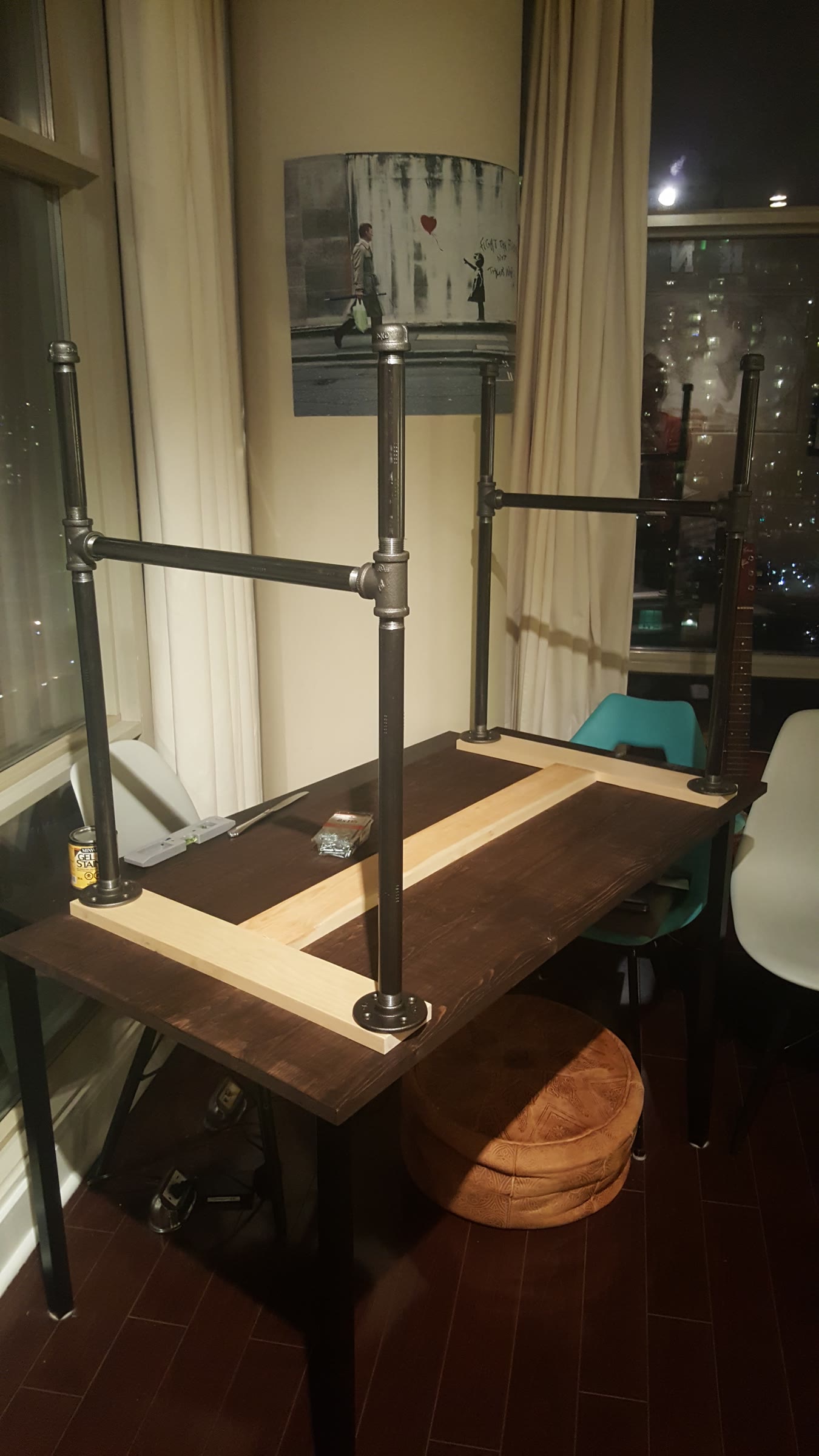 Tabletop upside down on a dining table with the black iron pipe leg frames attached and standing upright