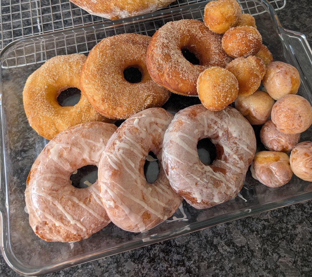 Full tray of glazed and cinnamon-sugar sourdough discard donuts and donut holes