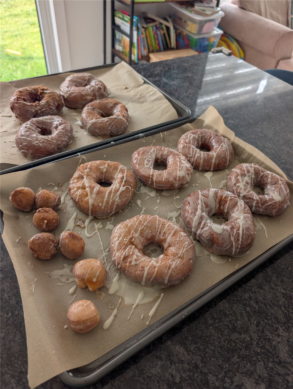 Trays of glazed and cinnamon-sugar sourdough discard donuts and donut holes