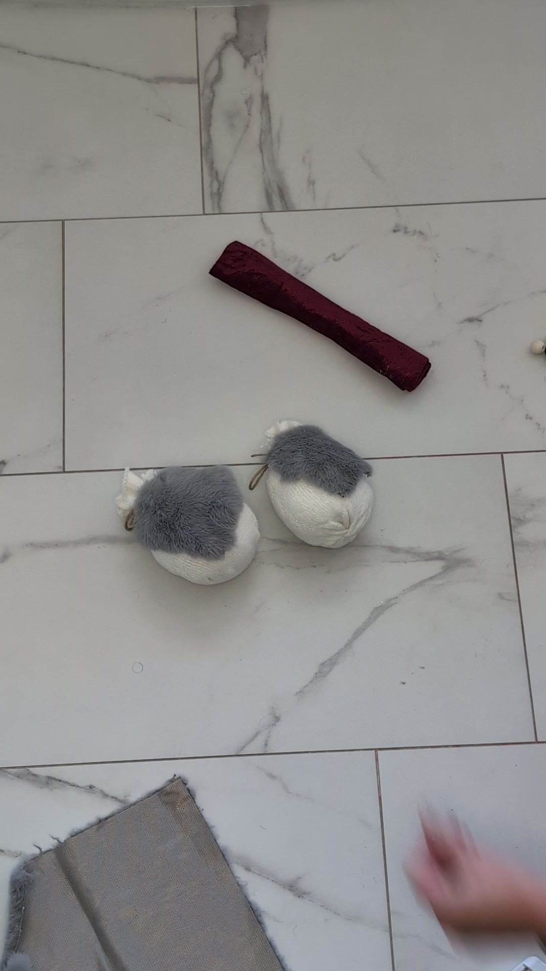 Two stuffed socks with grey faux fur beards hot glued onto the front