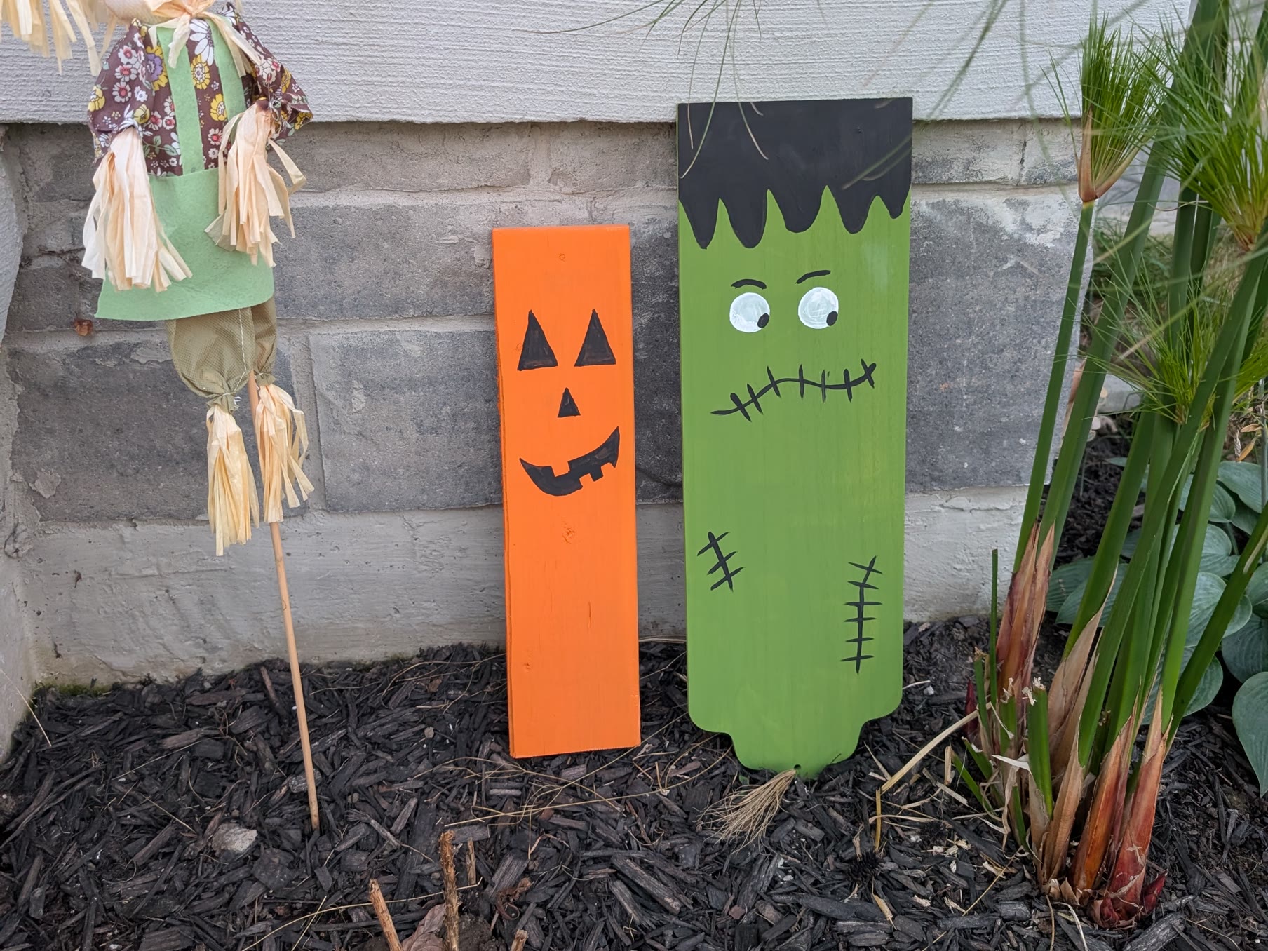 Painted orange jack-o-lantern and green Frankenstein wooden Halloween garden decorations