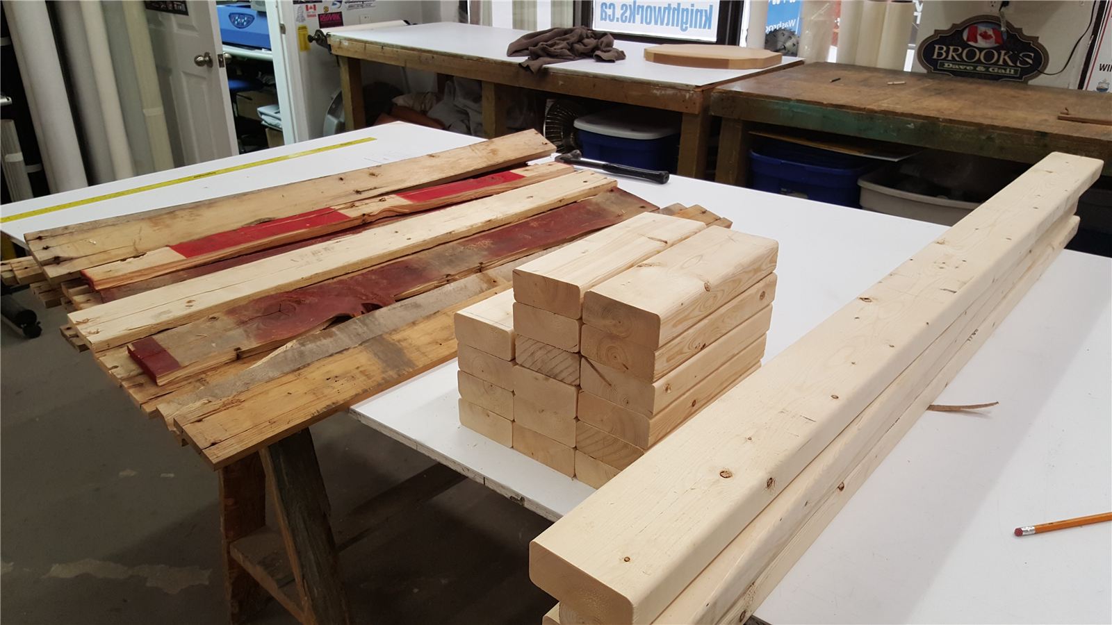 Cut and sanded reclaimed boards stacked next to cedar 4x4 posts on a workbench