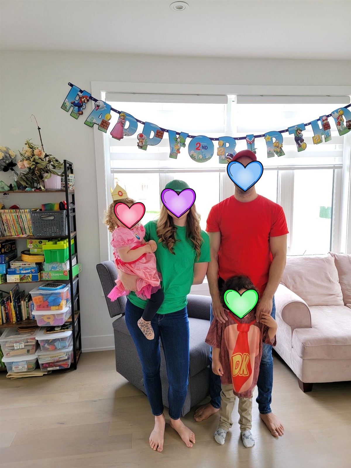 Family dressed up as Mario, Luigi, Princess Peach, and Donkey Kong in front of a happy birthday banner