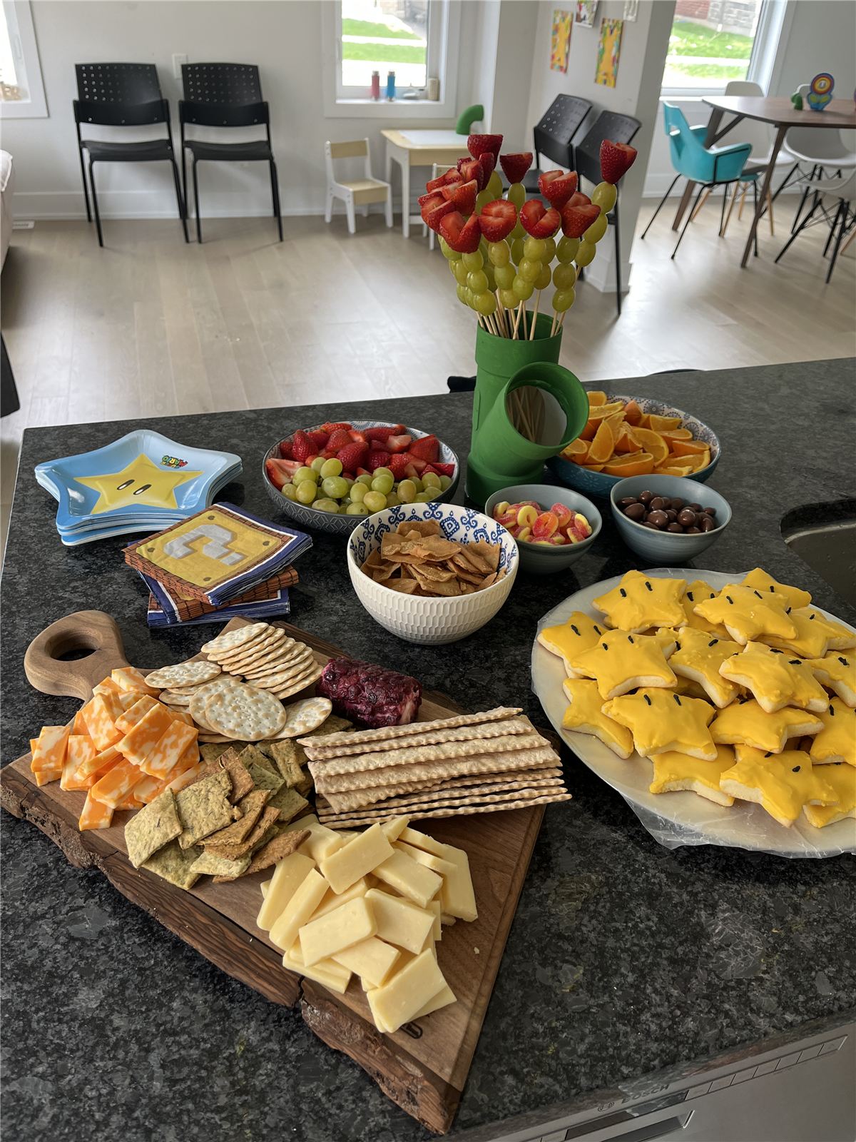 Super Mario themed food table with cheese board, fruit skewers, and star sugar cookies