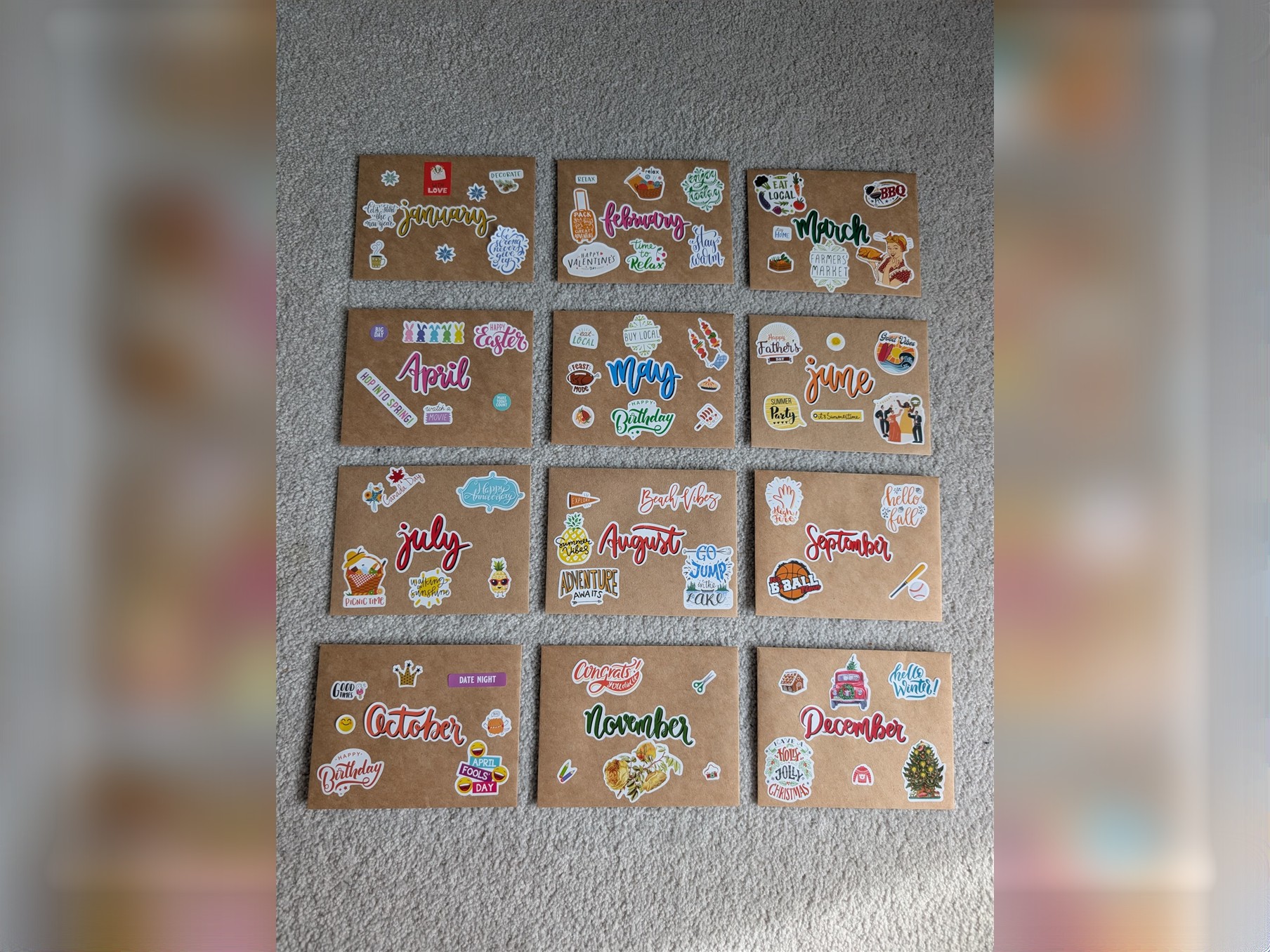 Twelve sticker-covered kraft envelopes, one for each month of the year