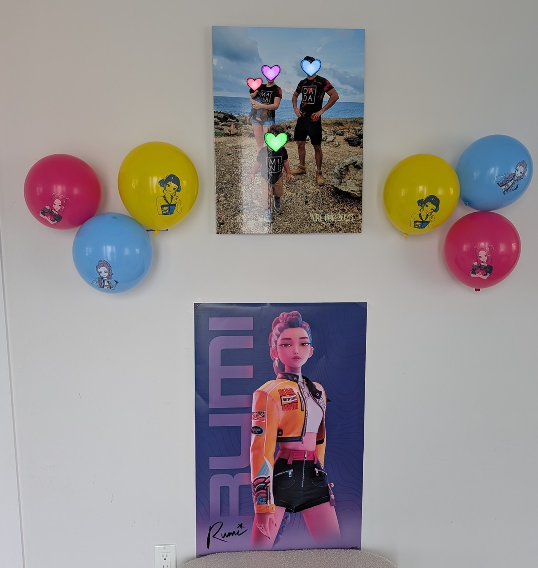 Photo backdrop wall with Rumi poster, balloons, and family photo