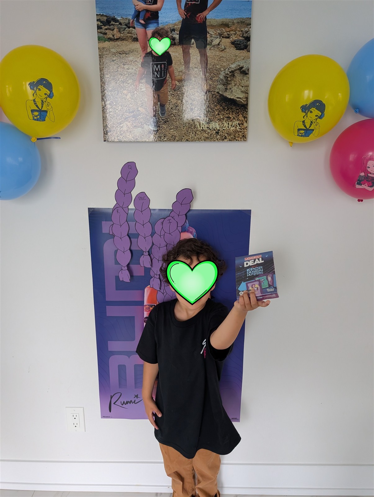Child holding a K-Pop Demon Hunters Monopoly Deal card game