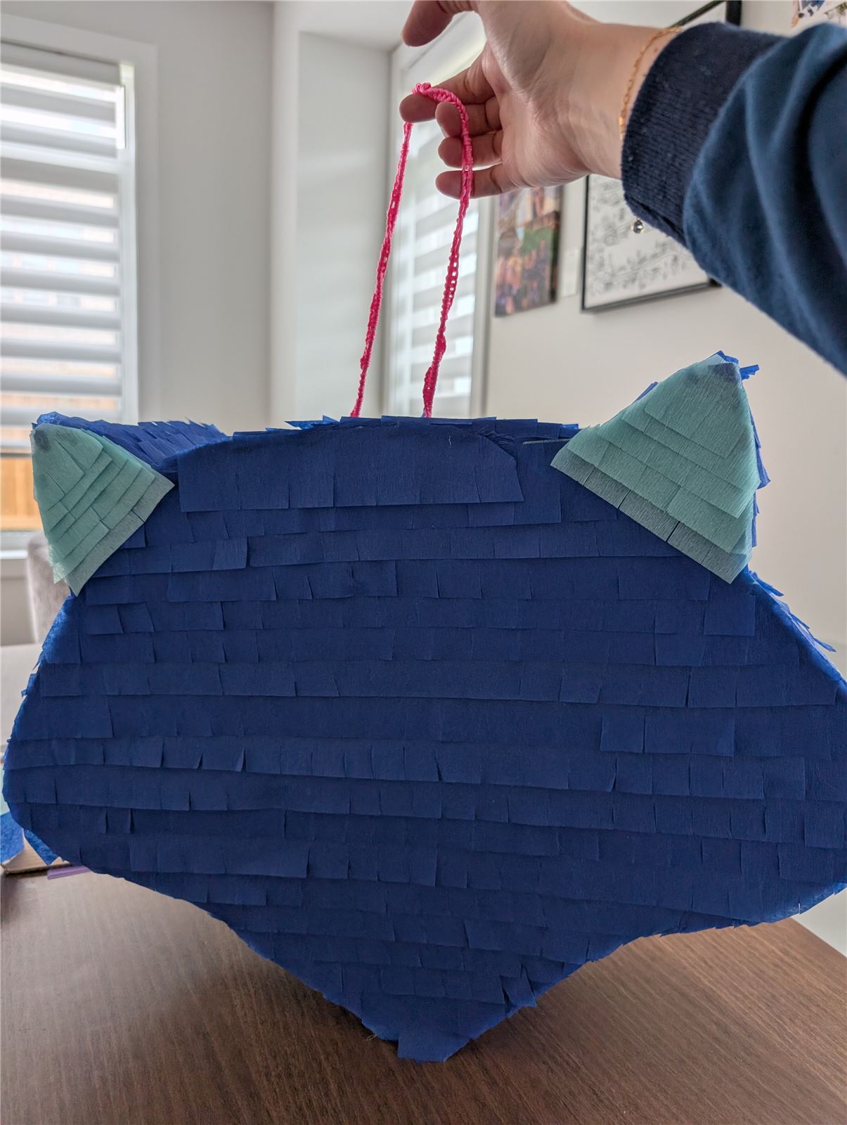 Cardboard pinata fully covered in navy blue crepe paper fringe