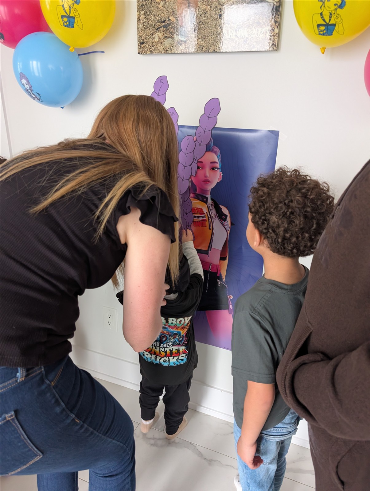 Kids playing pin the braid on the Rumi poster