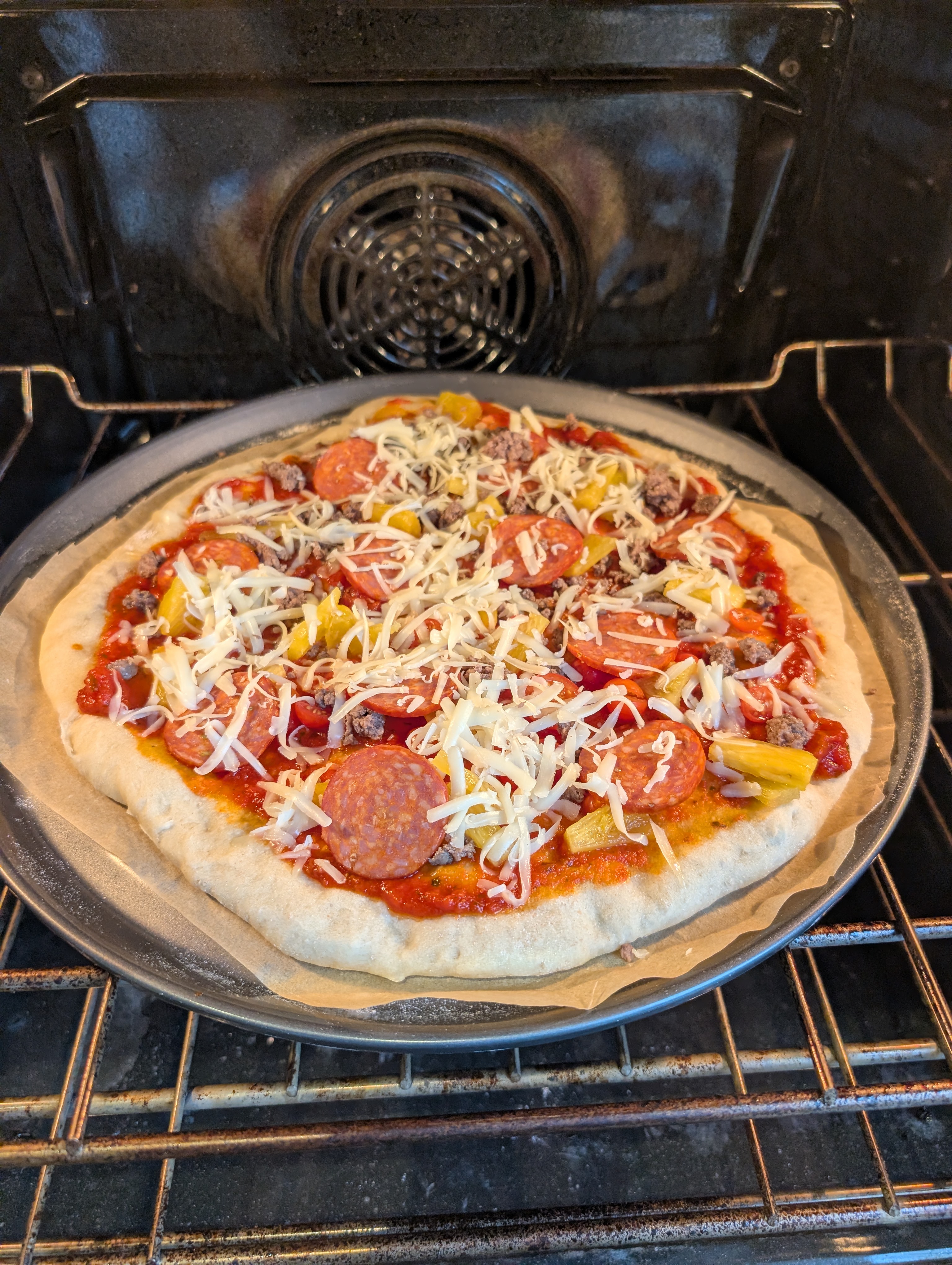 Topped sourdough pizza baking in the oven