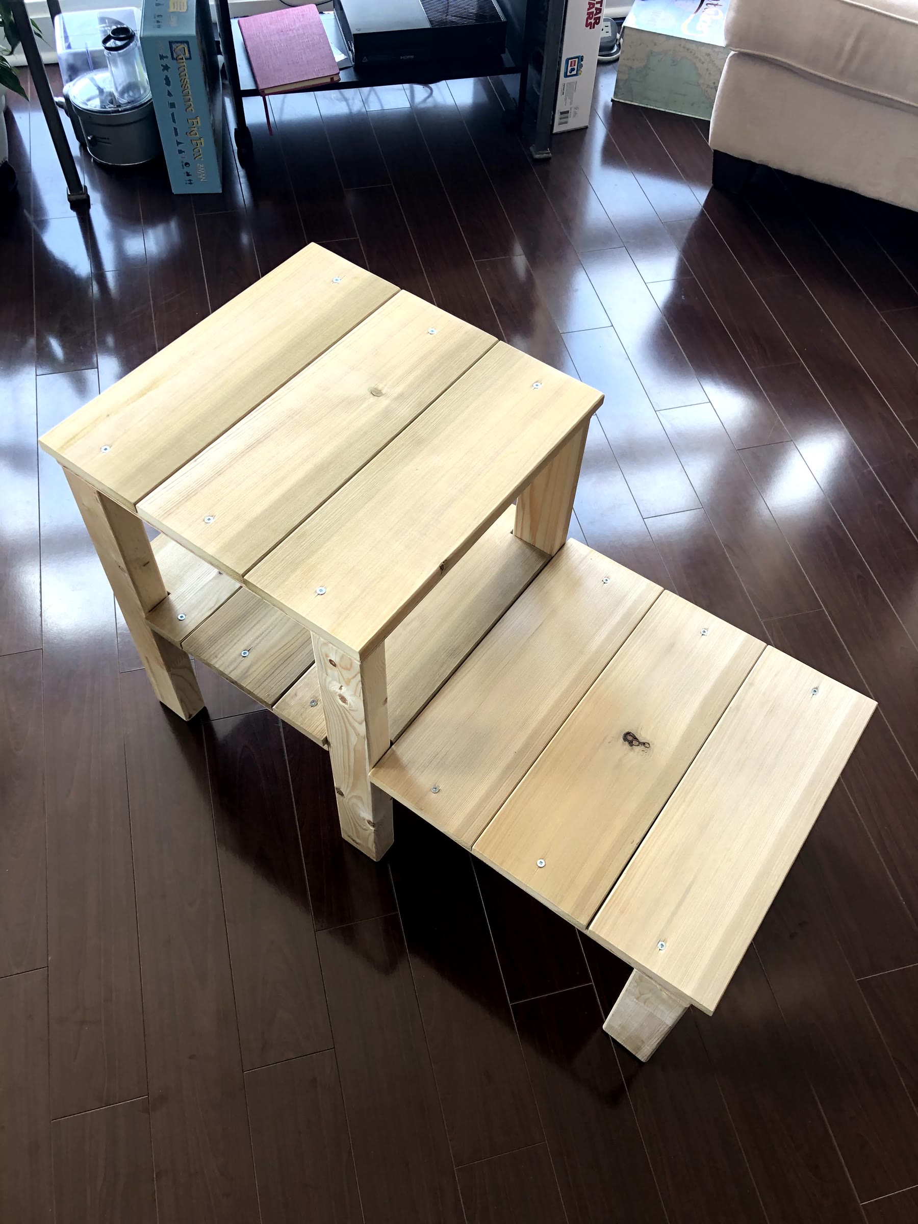 Unstained plant stand seen from above, with a tall three-board platform and a long low platform made of six boards