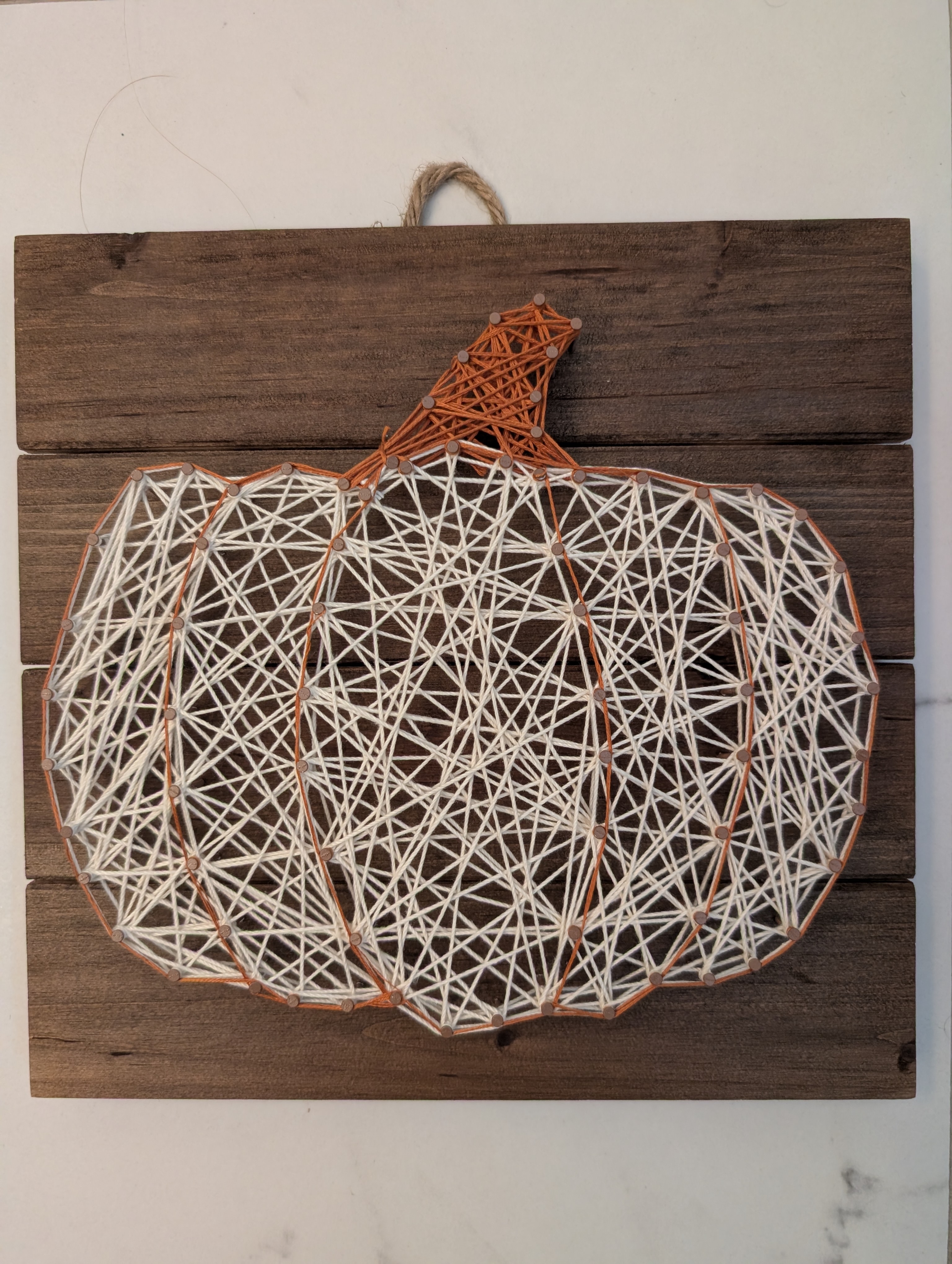 Finished pumpkin string art with a jute twine hanging loop attached